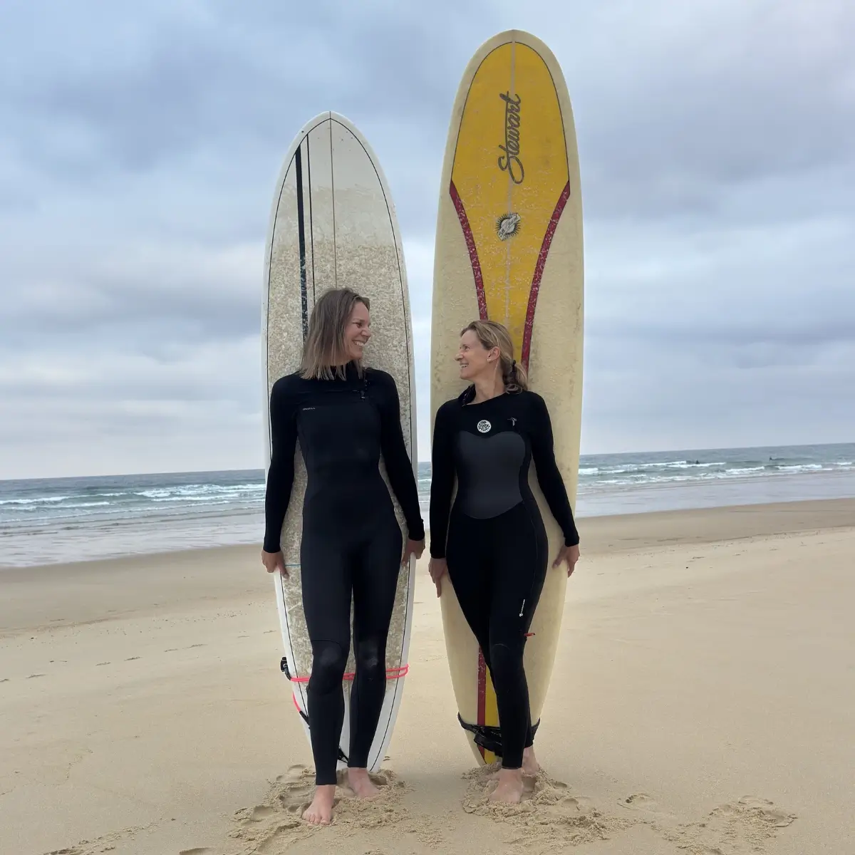 Zwei Surferinnen mit Longboards am Atlantik